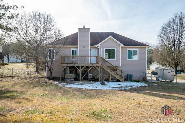 back of property with a deck, cooling unit, and a yard