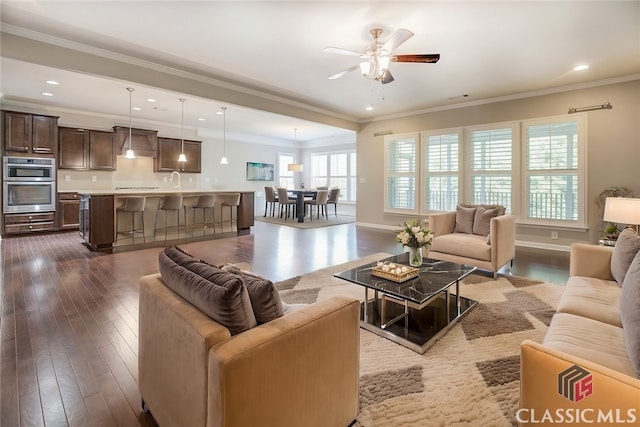 living room with ceiling fan, dark hardwood / wood-style flooring, and crown molding