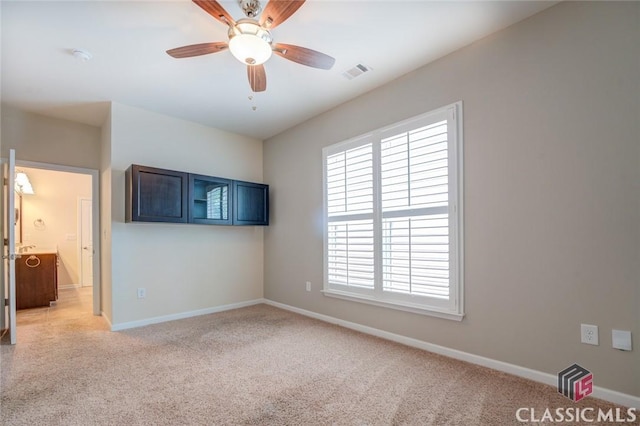 carpeted empty room featuring ceiling fan