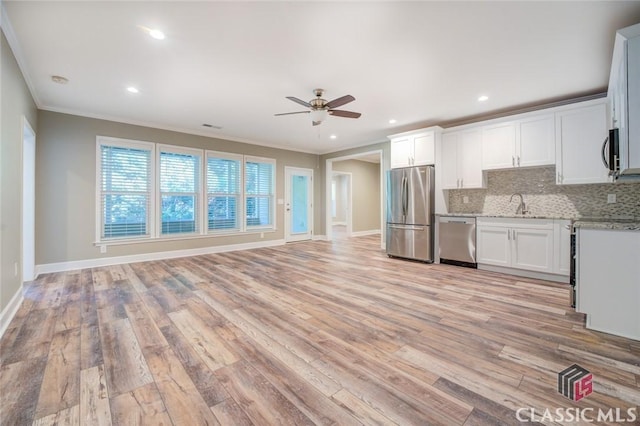 kitchen featuring white cabinets, appliances with stainless steel finishes, tasteful backsplash, light wood-type flooring, and ceiling fan