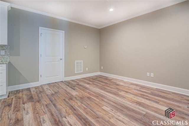 unfurnished room with crown molding and light hardwood / wood-style floors