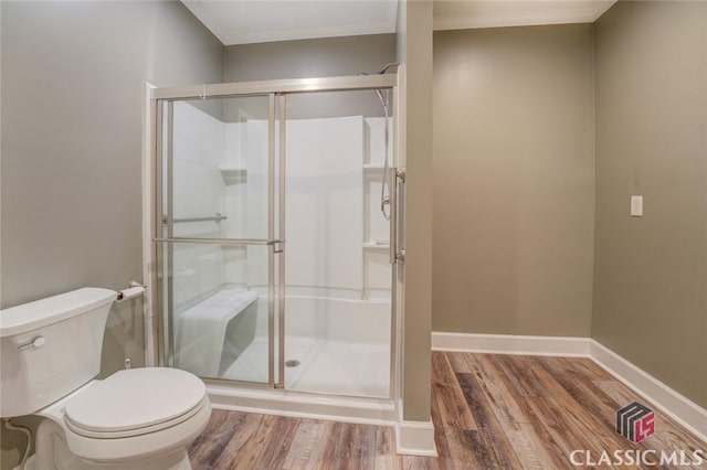 bathroom featuring a shower with shower door, wood-type flooring, toilet, and crown molding