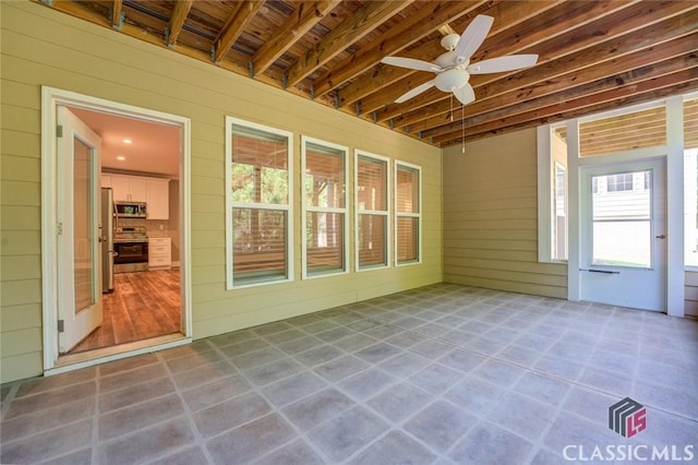 unfurnished sunroom with ceiling fan