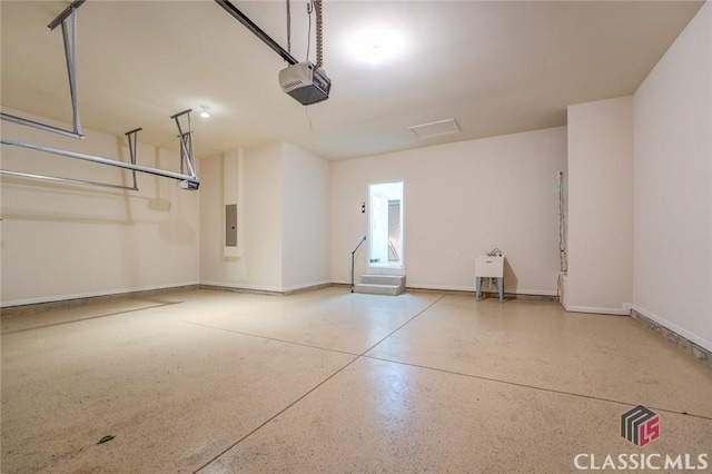 garage with a garage door opener and electric panel