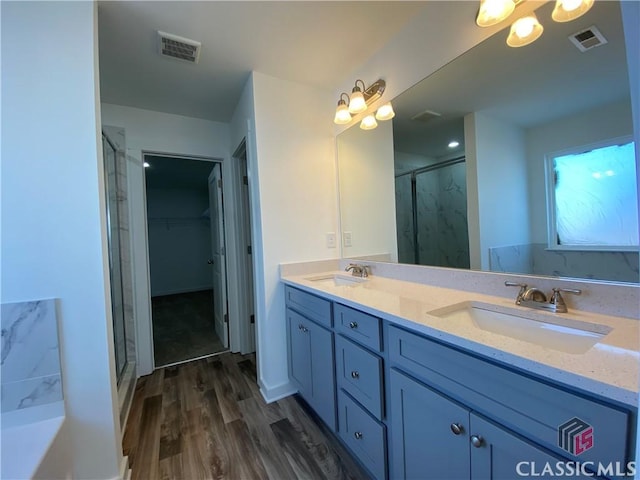 bathroom featuring walk in shower, vanity, and hardwood / wood-style flooring