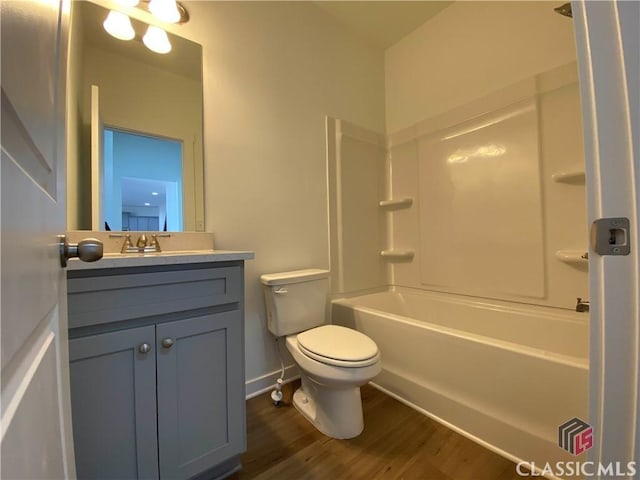 full bathroom with hardwood / wood-style flooring, shower / bathing tub combination, toilet, and vanity