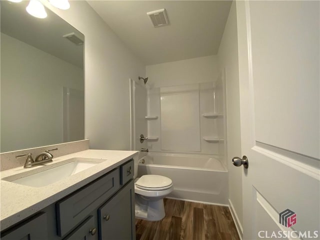 full bathroom featuring hardwood / wood-style flooring, bathtub / shower combination, toilet, and vanity