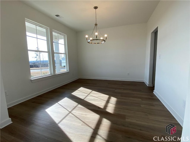 unfurnished dining area with dark wood-type flooring and a chandelier