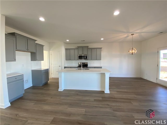 kitchen featuring sink, an inviting chandelier, an island with sink, gray cabinetry, and stainless steel appliances