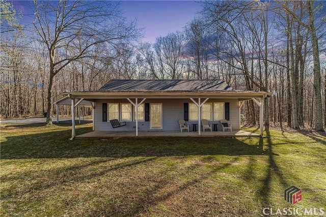 view of front of property with a patio area and a yard