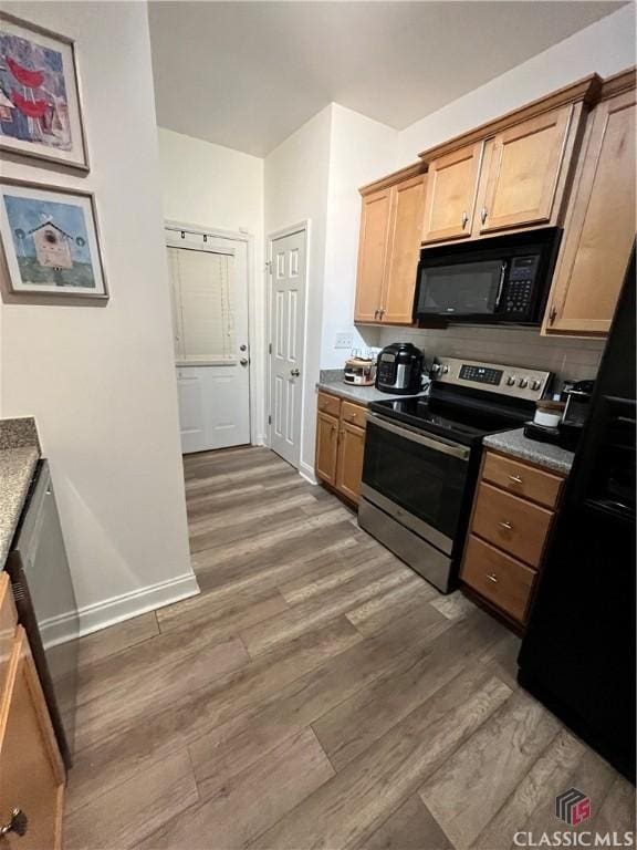 kitchen featuring black appliances and dark hardwood / wood-style floors