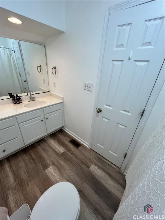 bathroom featuring vanity, toilet, and wood-type flooring