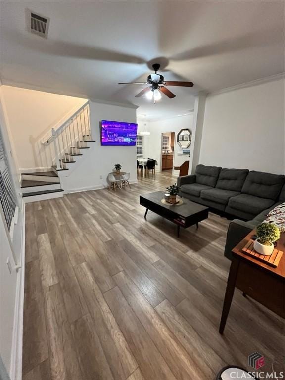 living room with ceiling fan, ornamental molding, and wood-type flooring