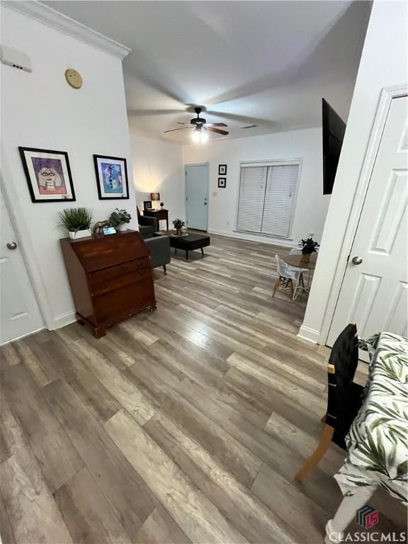 bedroom with ornamental molding, ceiling fan, and hardwood / wood-style floors