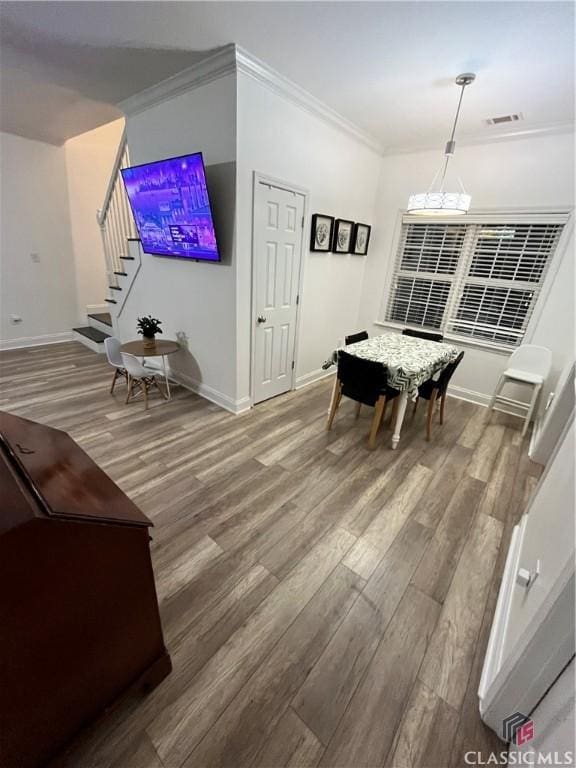 dining room featuring crown molding, hardwood / wood-style floors, and an inviting chandelier