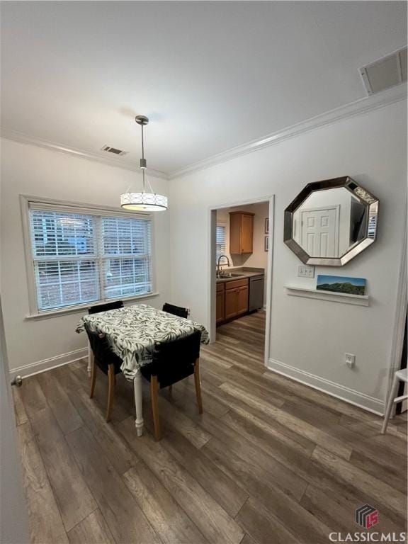 dining room featuring sink, dark hardwood / wood-style flooring, and ornamental molding