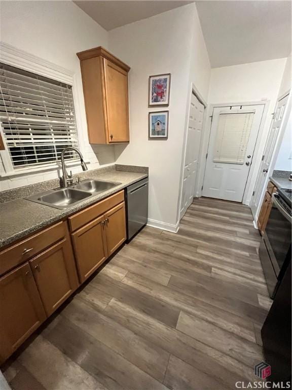 kitchen with sink, dark wood-type flooring, dishwashing machine, and stainless steel range with electric stovetop