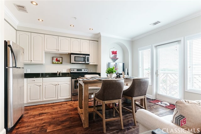 kitchen featuring dark wood-type flooring, appliances with stainless steel finishes, and white cabinets