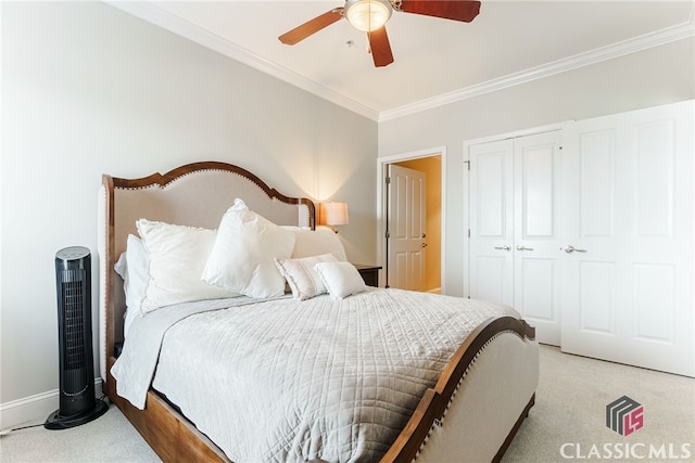 carpeted bedroom featuring ceiling fan, a closet, and crown molding