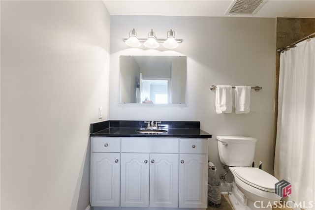 bathroom with toilet, vanity, and a shower with curtain