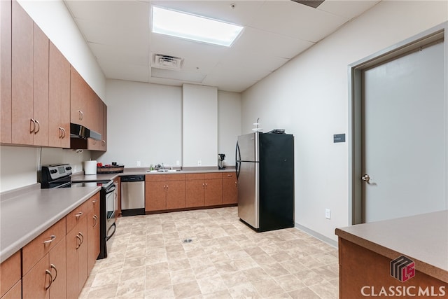 kitchen with stainless steel appliances, a drop ceiling, and sink