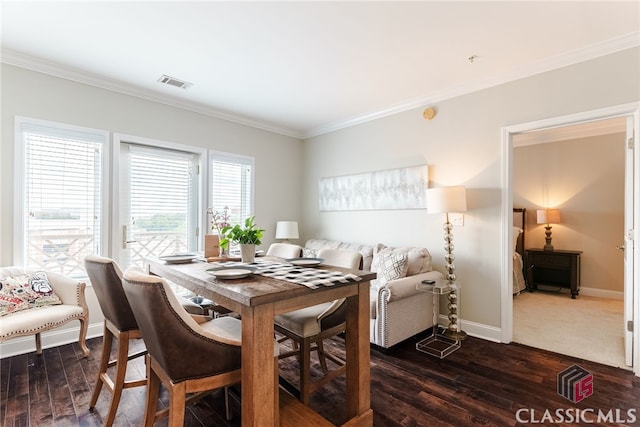 dining area featuring ornamental molding and dark hardwood / wood-style floors