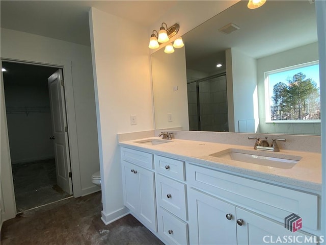 bathroom featuring toilet, vanity, and a shower with door