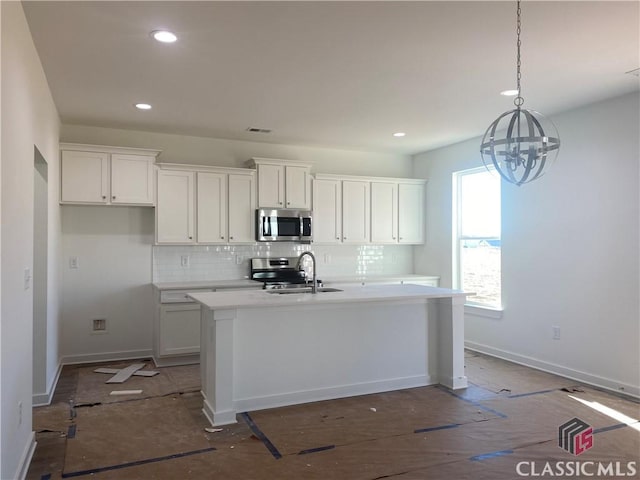 kitchen featuring a kitchen island with sink, appliances with stainless steel finishes, sink, and white cabinetry