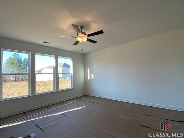 spare room featuring ceiling fan and a wealth of natural light