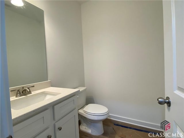 bathroom with toilet, vanity, and tile patterned floors