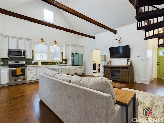 living room featuring beam ceiling, dark wood-type flooring, sink, and high vaulted ceiling