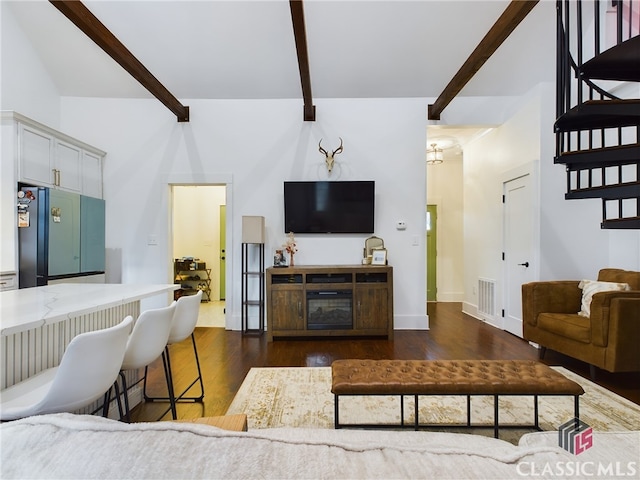 living room with beam ceiling, dark hardwood / wood-style floors, and a notable chandelier