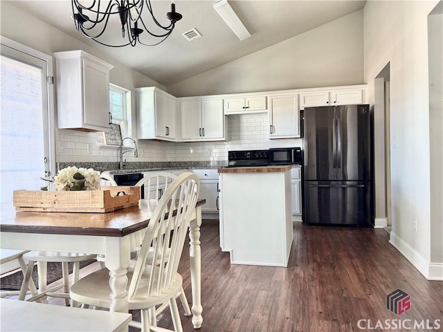 kitchen featuring a center island, dark wood-type flooring, white cabinetry, hanging light fixtures, and refrigerator