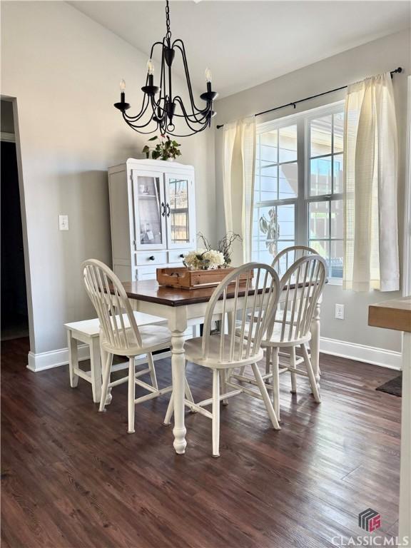 dining area featuring dark hardwood / wood-style floors and an inviting chandelier