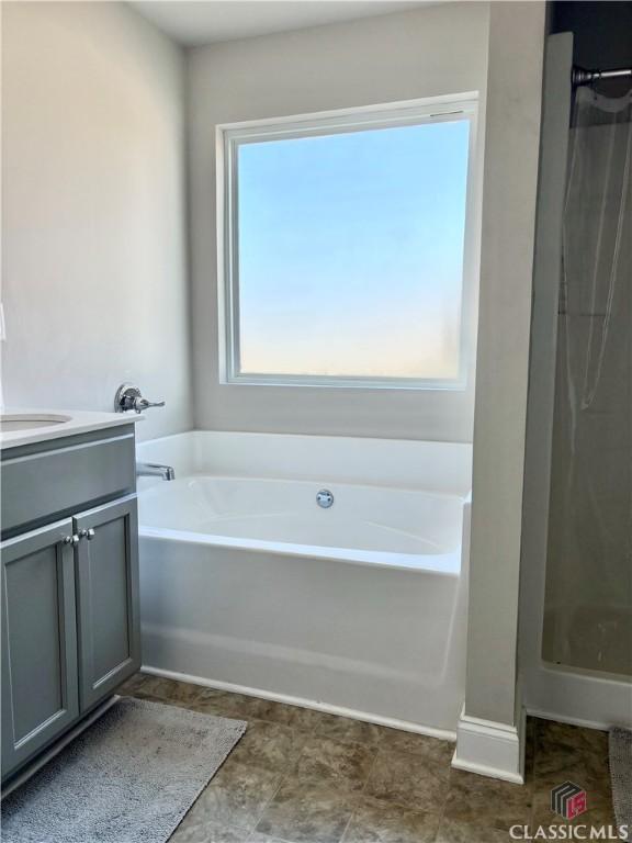 bathroom with vanity and shower with separate bathtub