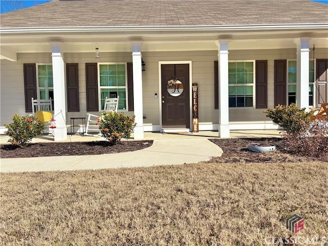 view of exterior entry featuring covered porch