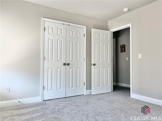 unfurnished bedroom featuring light carpet and a closet