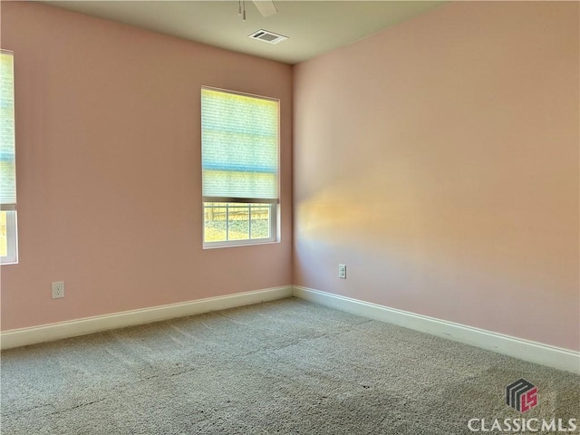 spare room with carpet floors, a healthy amount of sunlight, and ceiling fan