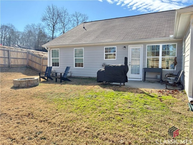 back of house with a patio area, a lawn, and a fire pit