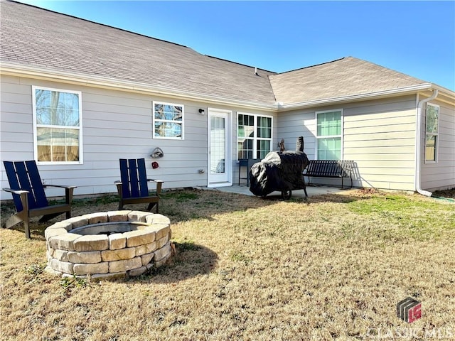 back of house with a lawn, a patio, and a fire pit