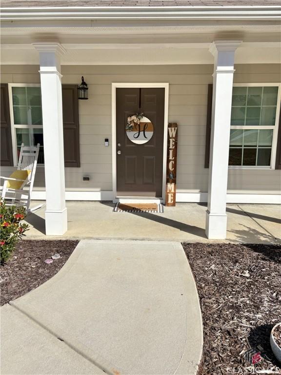 view of exterior entry featuring covered porch