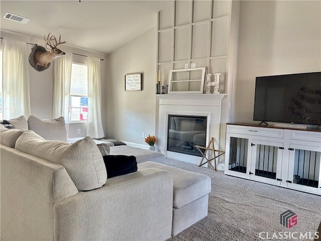 carpeted living room with vaulted ceiling