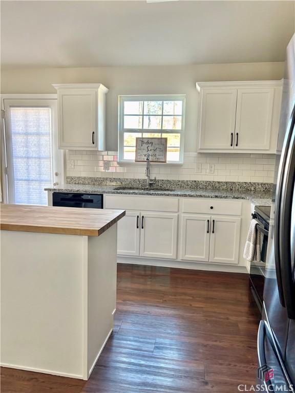 kitchen featuring butcher block counters, white cabinets, and sink