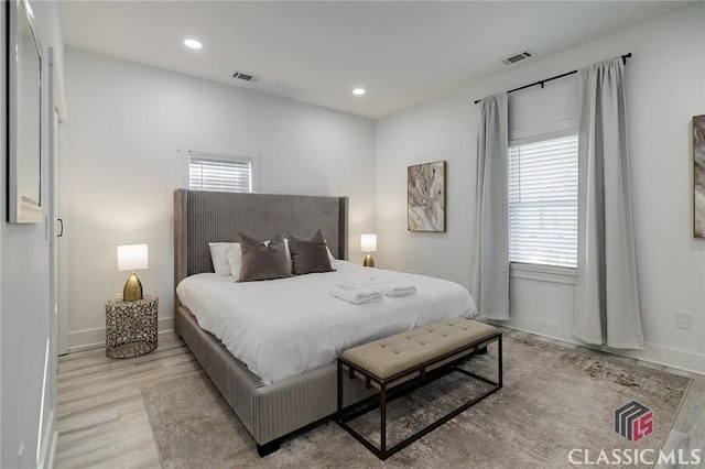 bedroom with light hardwood / wood-style floors and multiple windows