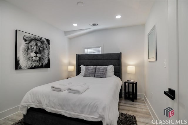 bedroom featuring vaulted ceiling and light hardwood / wood-style floors