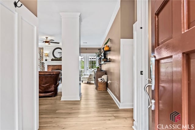 foyer entrance featuring light hardwood / wood-style floors, french doors, ornamental molding, and ornate columns