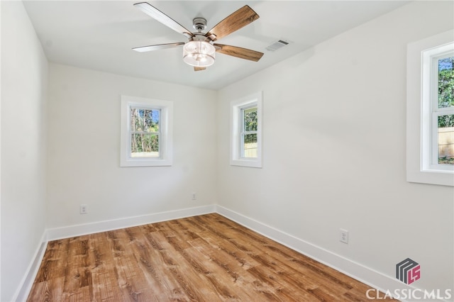 spare room with hardwood / wood-style flooring and ceiling fan