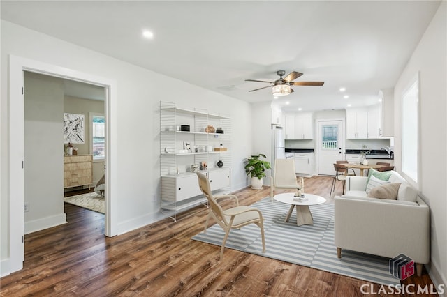 living room with plenty of natural light, ceiling fan, and dark hardwood / wood-style flooring