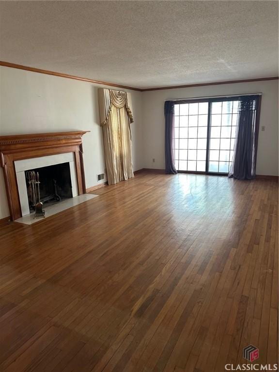 unfurnished living room featuring wood-type flooring, a textured ceiling, and ornamental molding