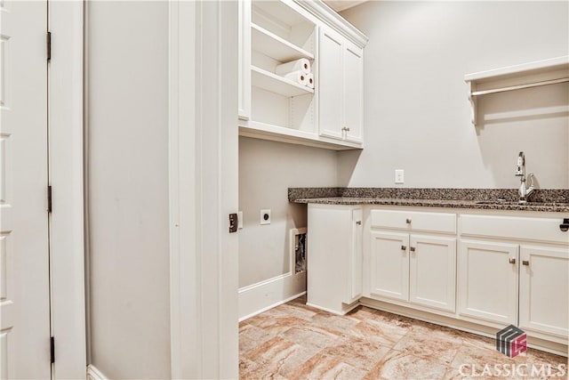 washroom with cabinets, hookup for an electric dryer, and sink